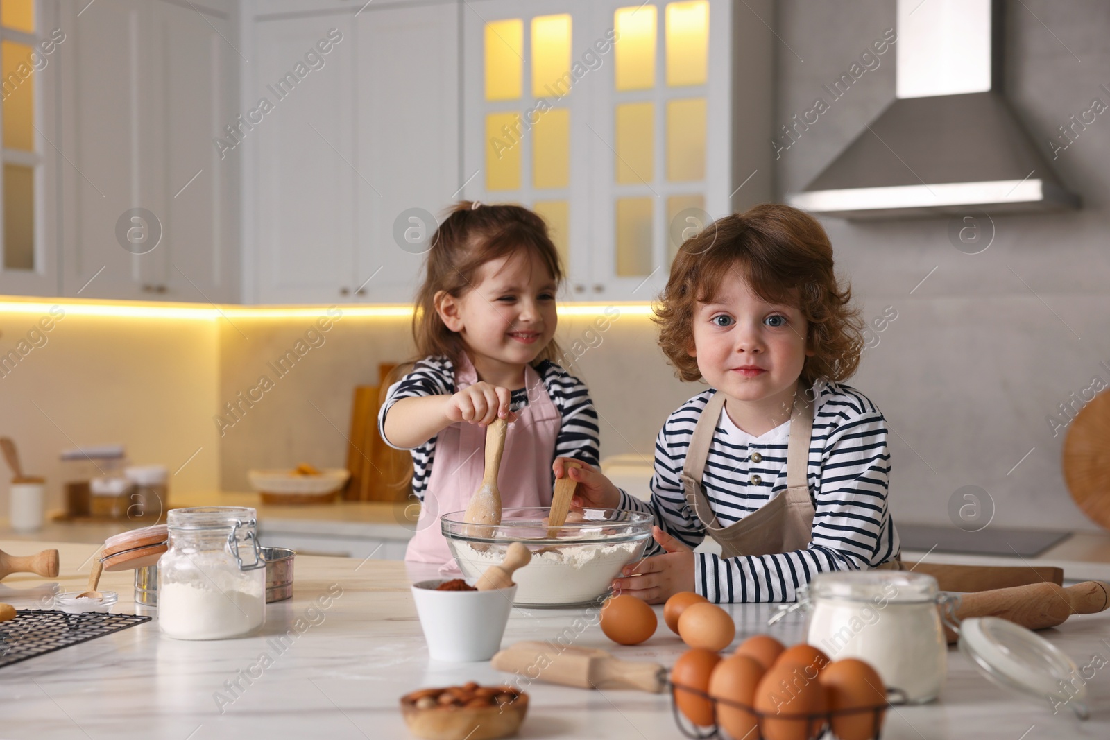 Cooking recipe. Cute children making dough for cookies at table in kitchen Photo of Cooking recipe. Cute children making dough for cookies at table in kitchen