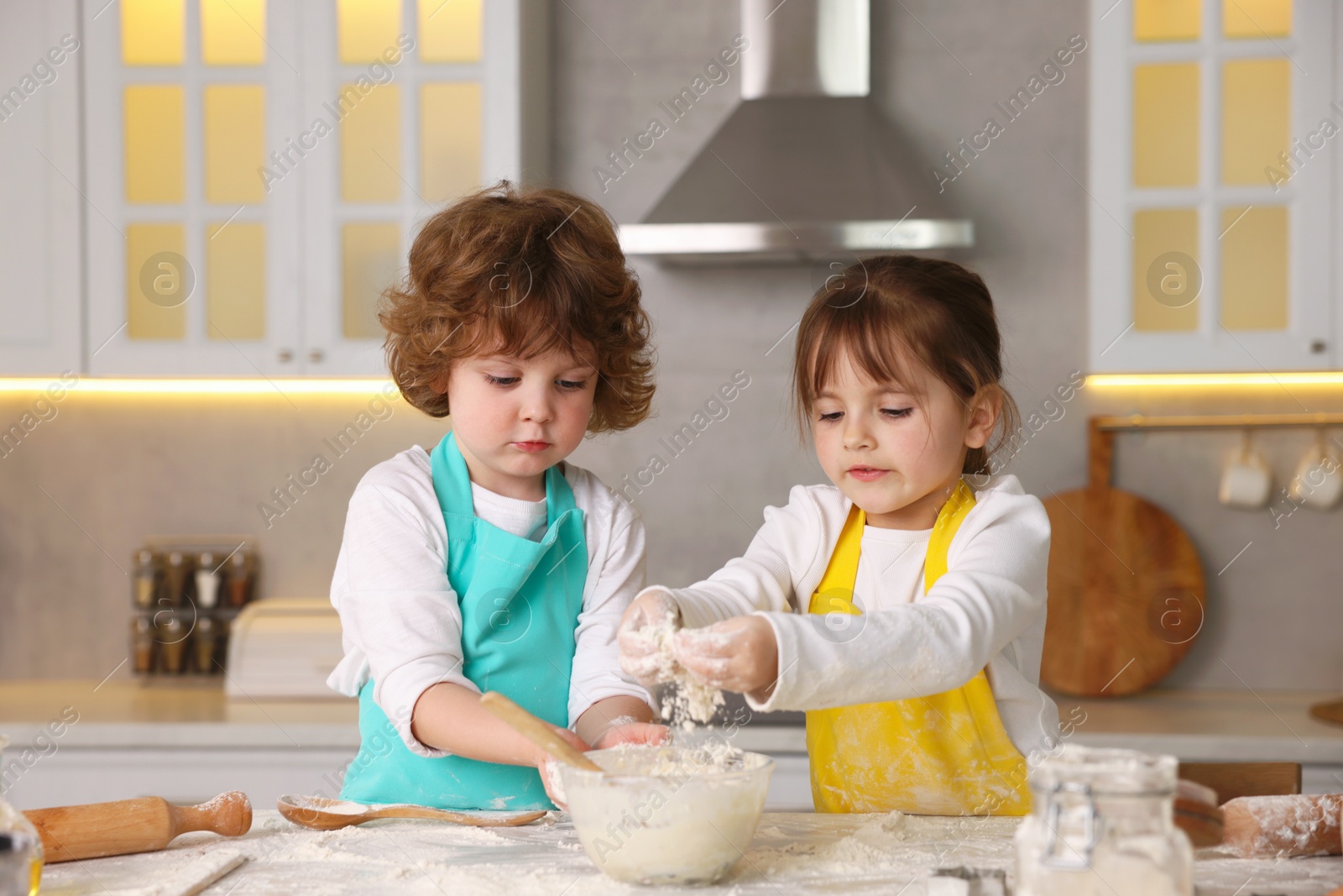 Cooking recipe. Cute children making dough for cookies at table in kitchen Photo of Cooking recipe. Cute children making dough for cookies at table in kitchen