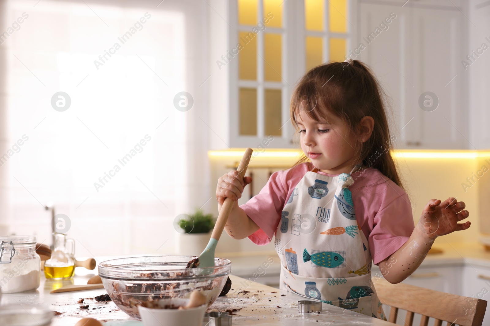 Cooking recipe. Little girl making dough for cookies at table in kitchen. Space for text Photo of Cooking recipe. Little girl making dough for cookies at table in kitchen. Space for text