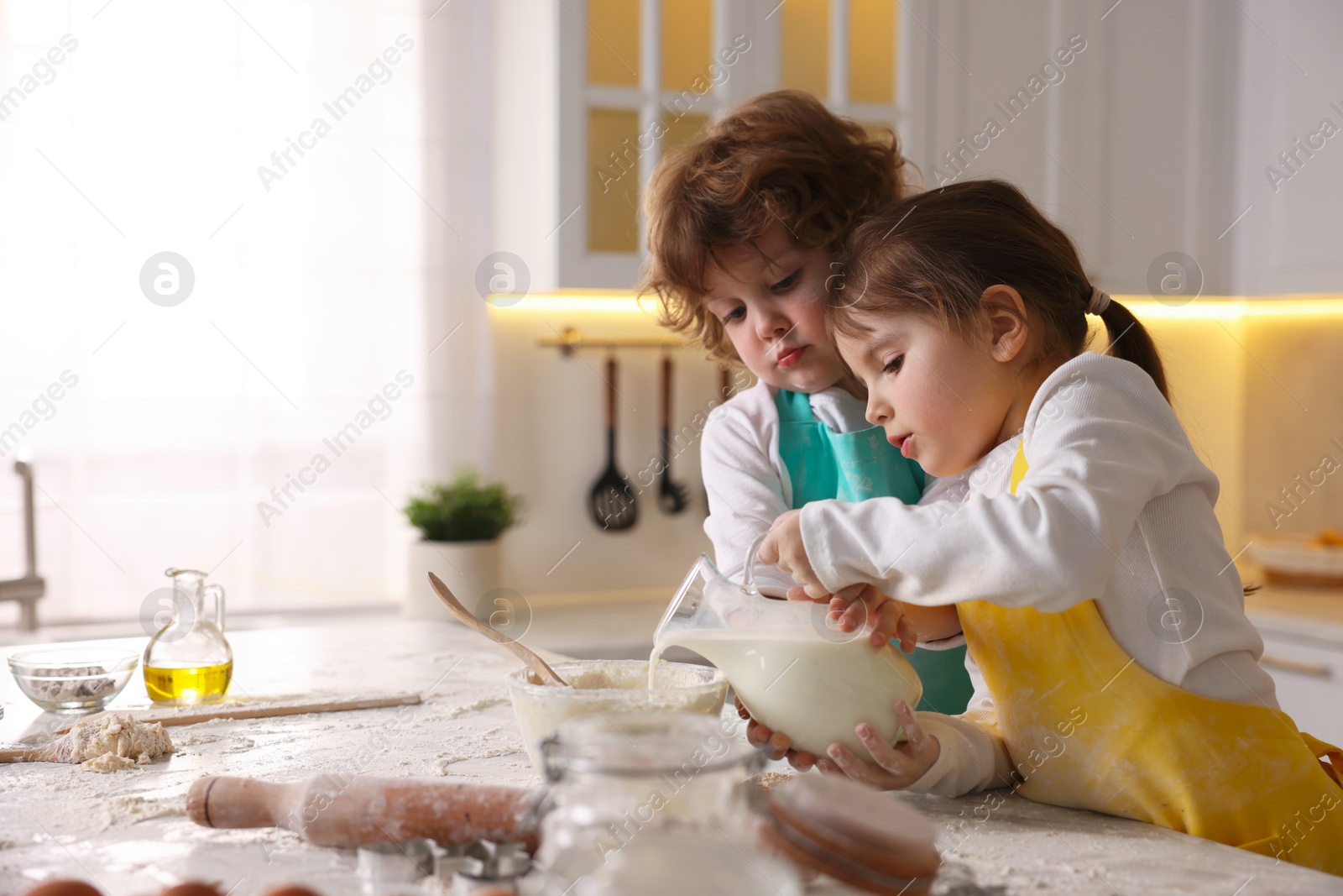 Cooking recipe. Cute children making dough for cookies at table in kitchen. Space for text Photo of Cooking recipe. Cute children making dough for cookies at table in kitchen. Space for text