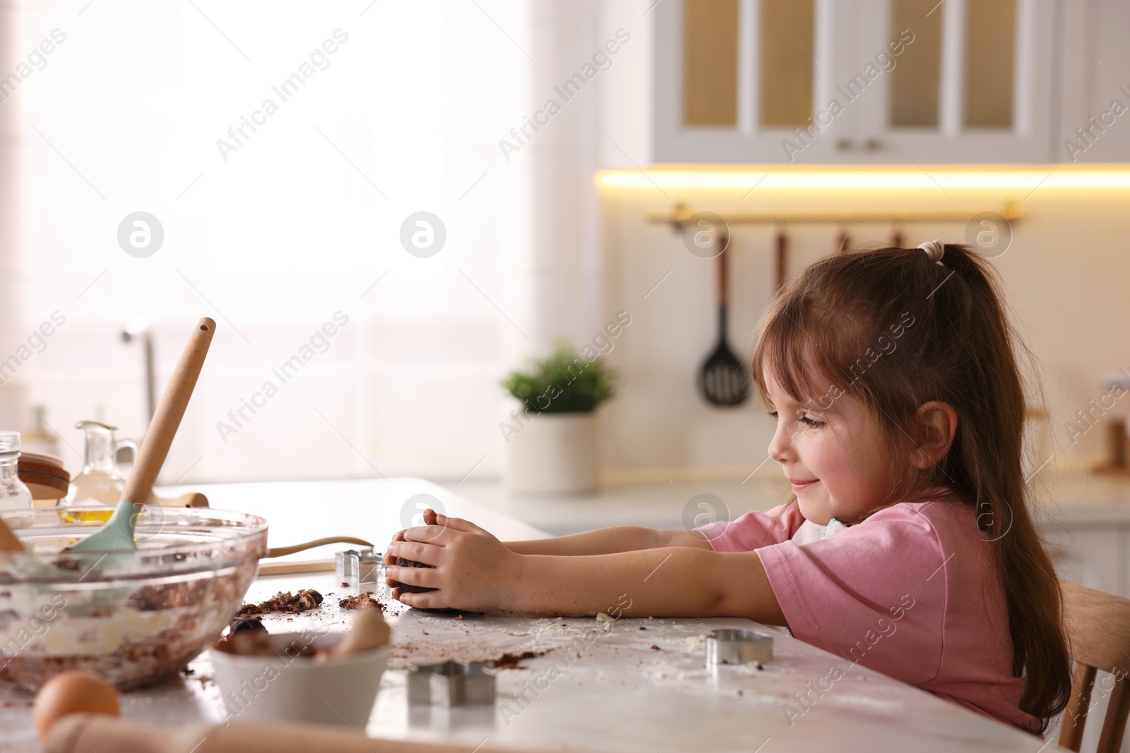 Cooking recipe. Little girl making dough for cookies at table in kitchen. Space for text Photo of Cooking recipe. Little girl making dough for cookies at table in kitchen. Space for text