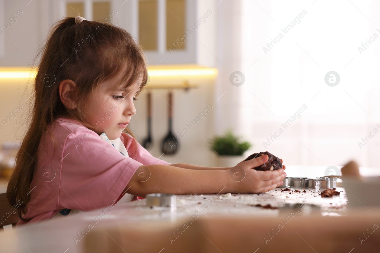 Cooking recipe. Little girl making dough for cookies at table in kitchen. Space for text Photo of Cooking recipe. Little girl making dough for cookies at table in kitchen. Space for text