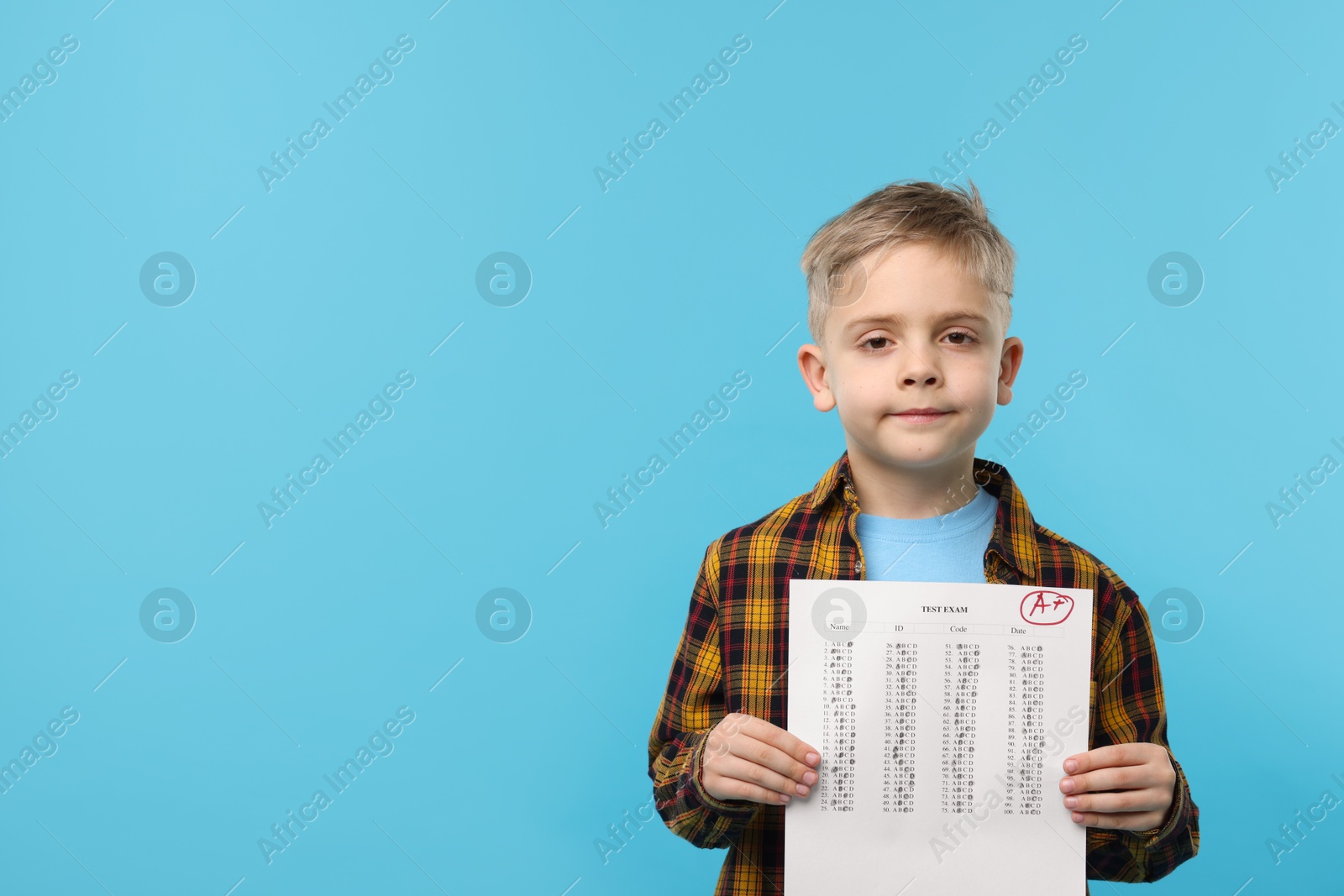 School grade. Little boy holding answer sheet with letter A and plus symbol on light blue background, space for text Photo of School grade. Little boy holding answer sheet with letter A and plus symbol on light blue background, space for text