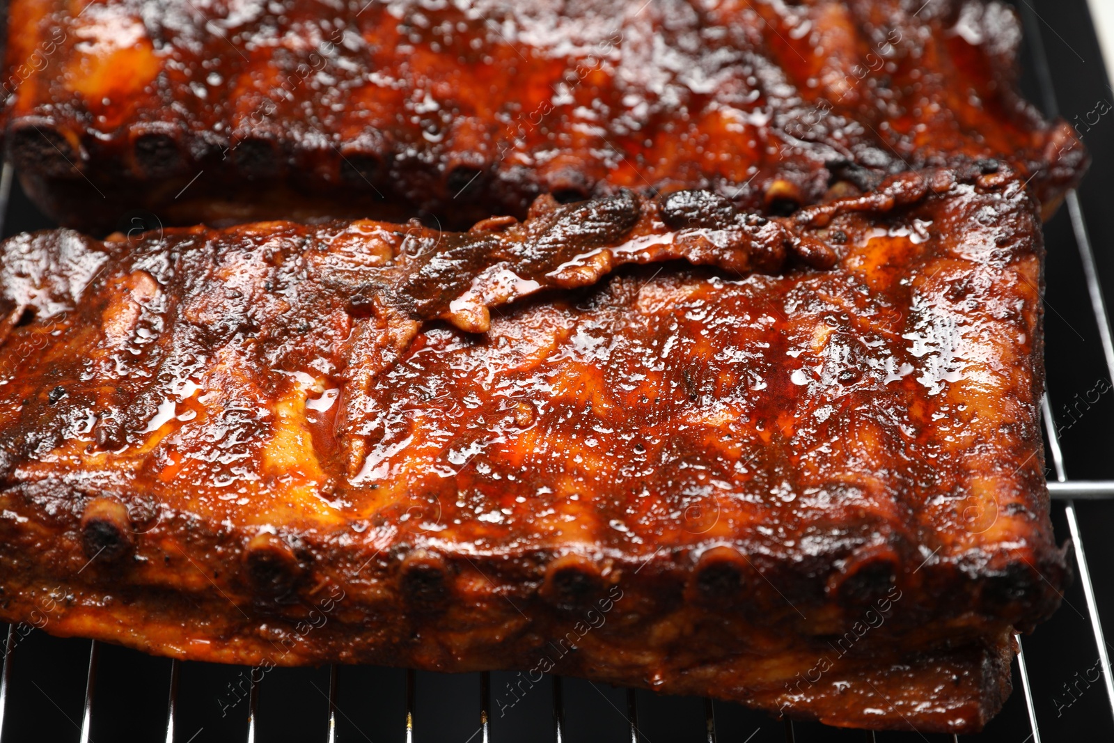 Delicious roasted pork ribs on grill, closeup Photo of Delicious roasted pork ribs on grill, closeup