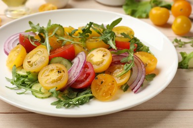 Photo of Fresh salad with yellow tomatoes on white wooden table, closeup