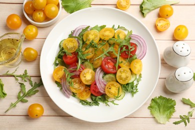 Photo of Fresh salad with yellow tomatoes on white wooden table, flat lay