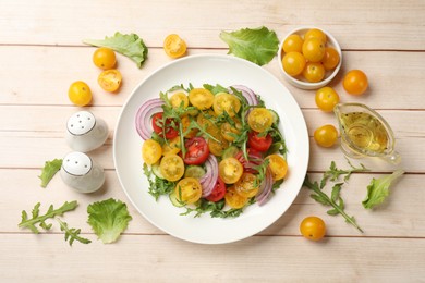 Photo of Fresh salad with yellow tomatoes on white wooden table, flat lay