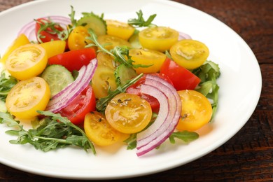 Photo of Fresh salad with yellow tomatoes on wooden table, closeup