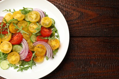 Photo of Fresh salad with yellow tomatoes on wooden table, top view. Space for text