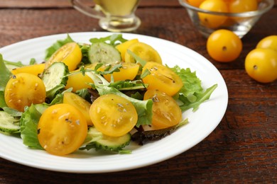 Photo of Fresh salad with yellow tomatoes on wooden table, closeup