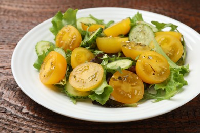 Photo of Fresh salad with yellow tomatoes on wooden table, closeup
