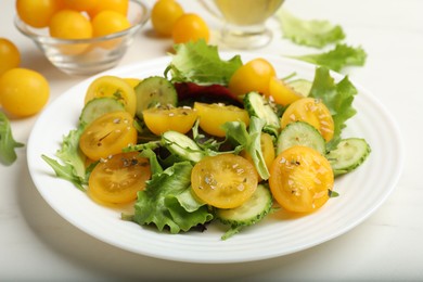 Photo of Fresh salad with yellow tomatoes on white table, closeup