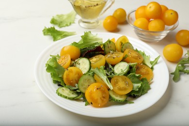 Photo of Fresh salad with yellow tomatoes on white table, closeup