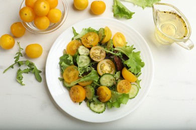 Photo of Fresh salad with yellow tomatoes on white table, flat lay