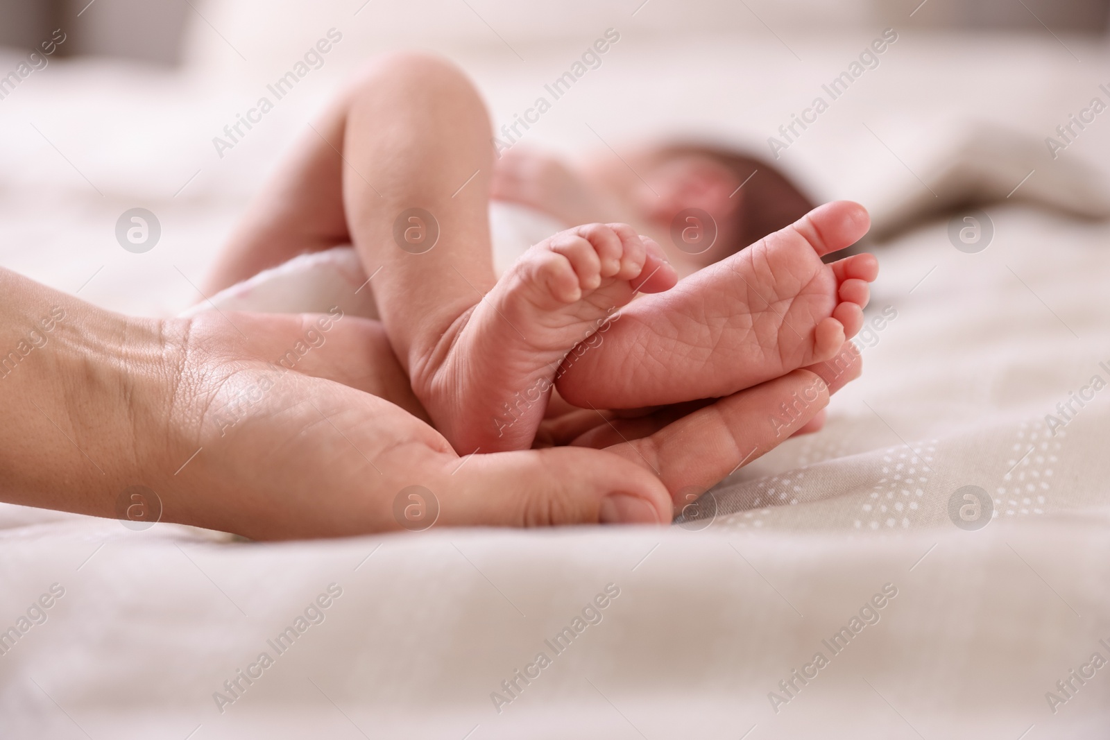 Mother with her little baby on bed indoors, closeup Photo of Mother with her little baby on bed indoors, closeup