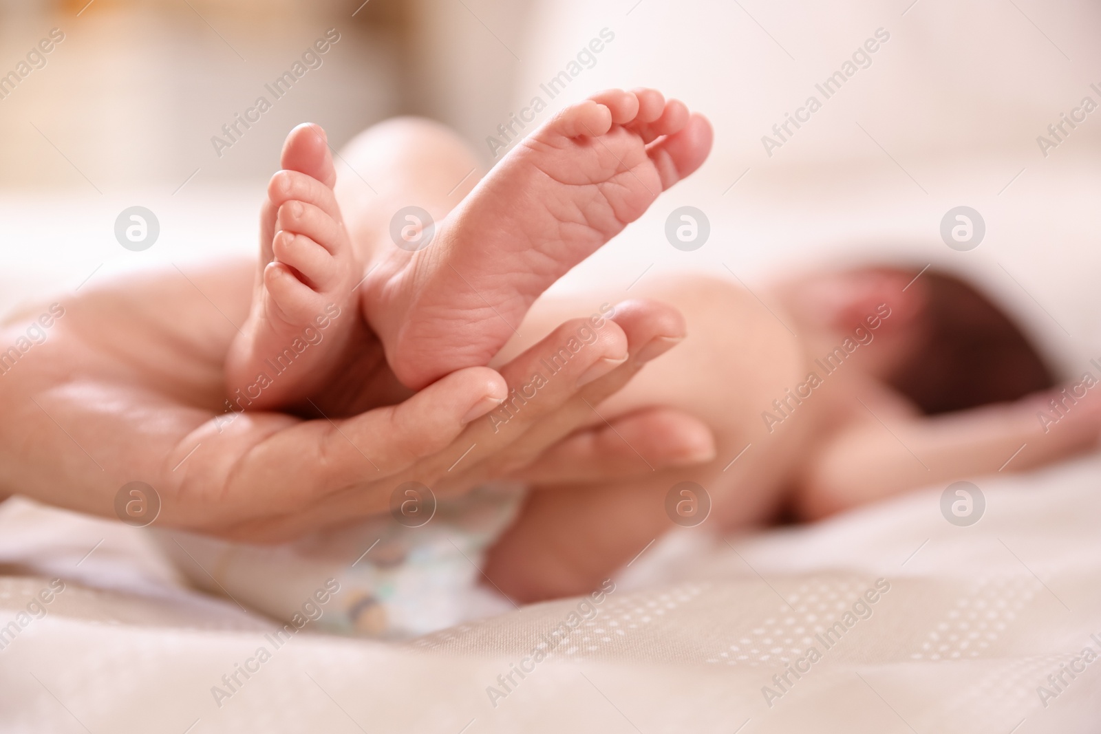 Mother with her little baby on bed indoors, closeup Photo of Mother with her little baby on bed indoors, closeup
