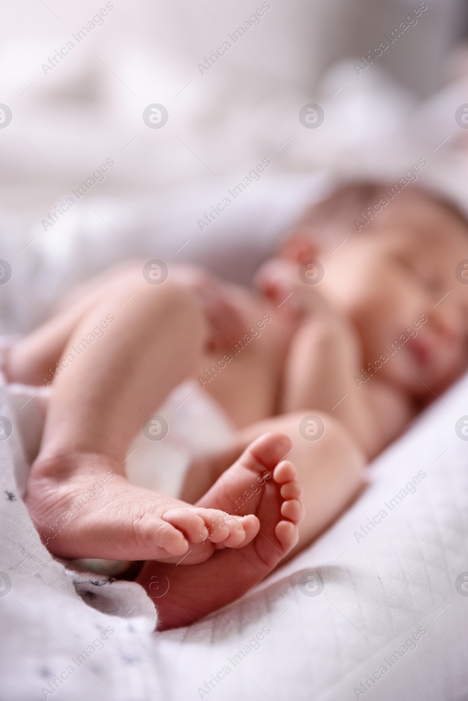 Little baby lying on bed indoors, selective focus Photo of Little baby lying on bed indoors, selective focus