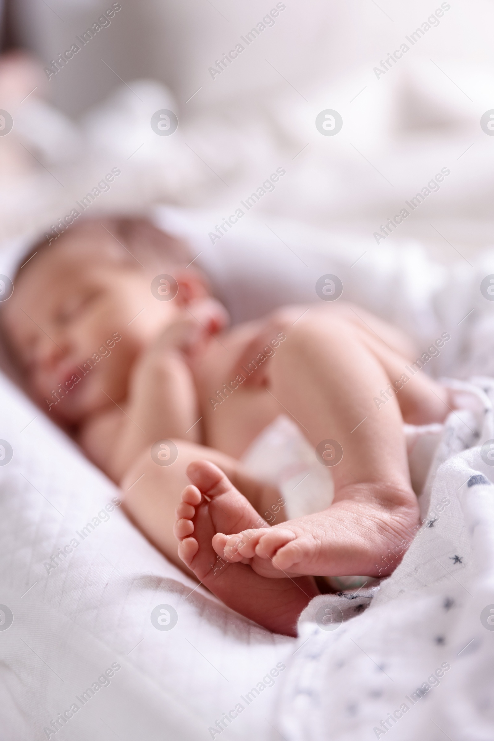 Little baby lying on bed indoors, selective focus Photo of Little baby lying on bed indoors, selective focus