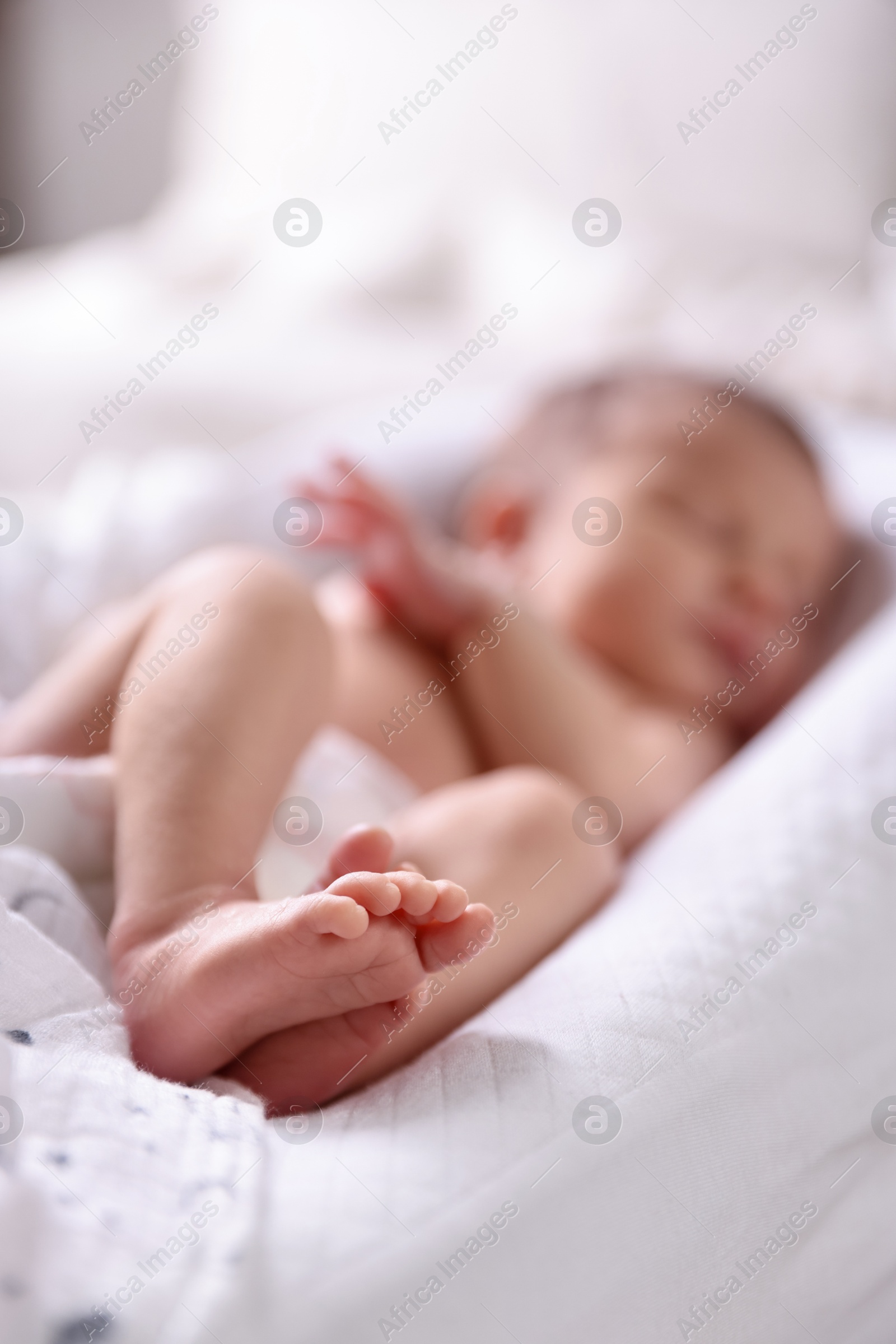 Little baby lying on bed indoors, selective focus Photo of Little baby lying on bed indoors, selective focus