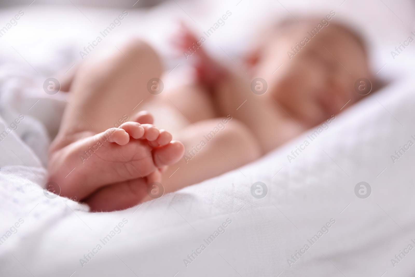 Little baby lying on bed indoors, selective focus Photo of Little baby lying on bed indoors, selective focus