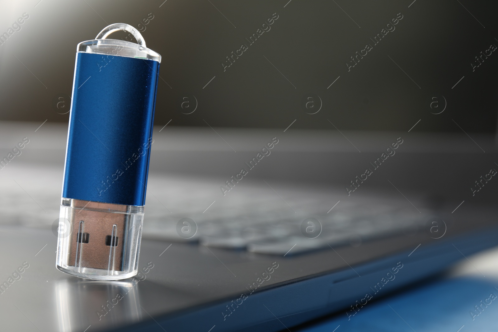 Flash drive and laptop on table, closeup. Space for text Photo of Flash drive and laptop on table, closeup. Space for text