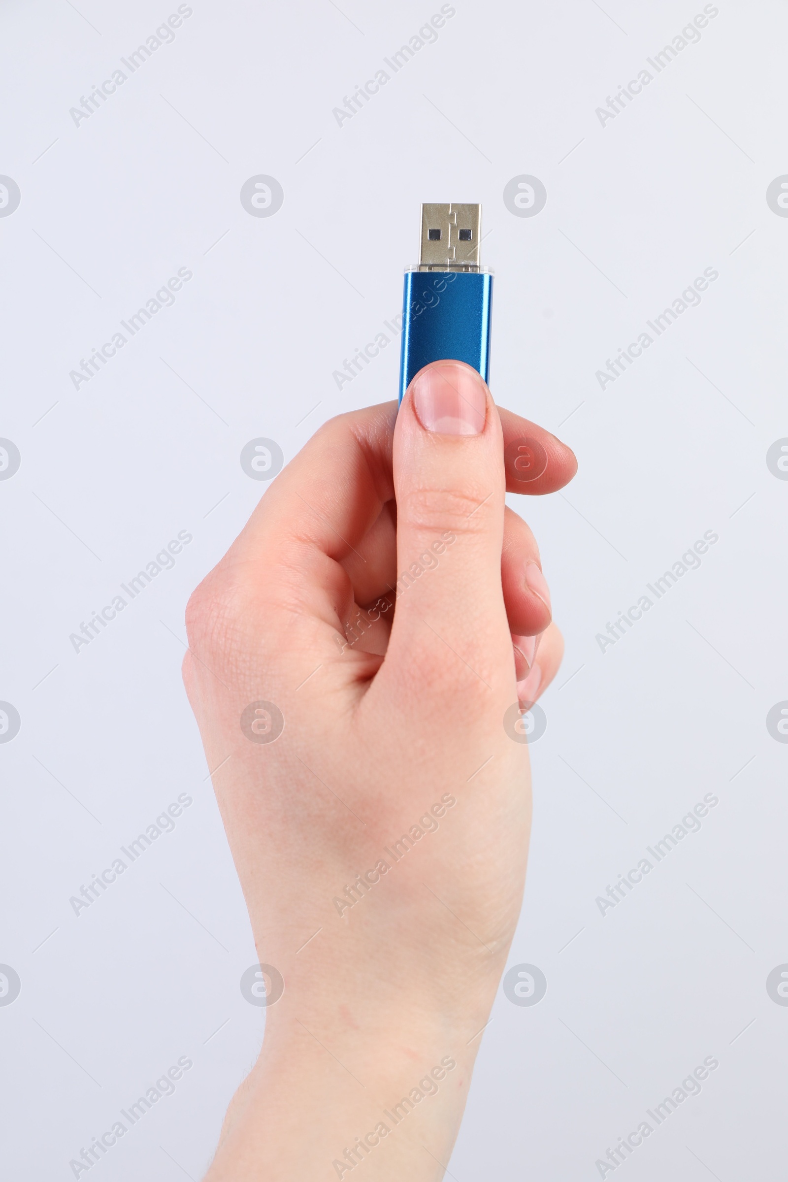 Man with modern flash drive on light grey background, closeup Photo of Man with modern flash drive on light grey background, closeup
