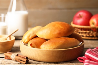 Photo of Tasty baked patties and ingredients on wooden table, closeup