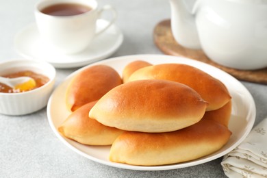 Photo of Tasty baked patties on light grey table, closeup