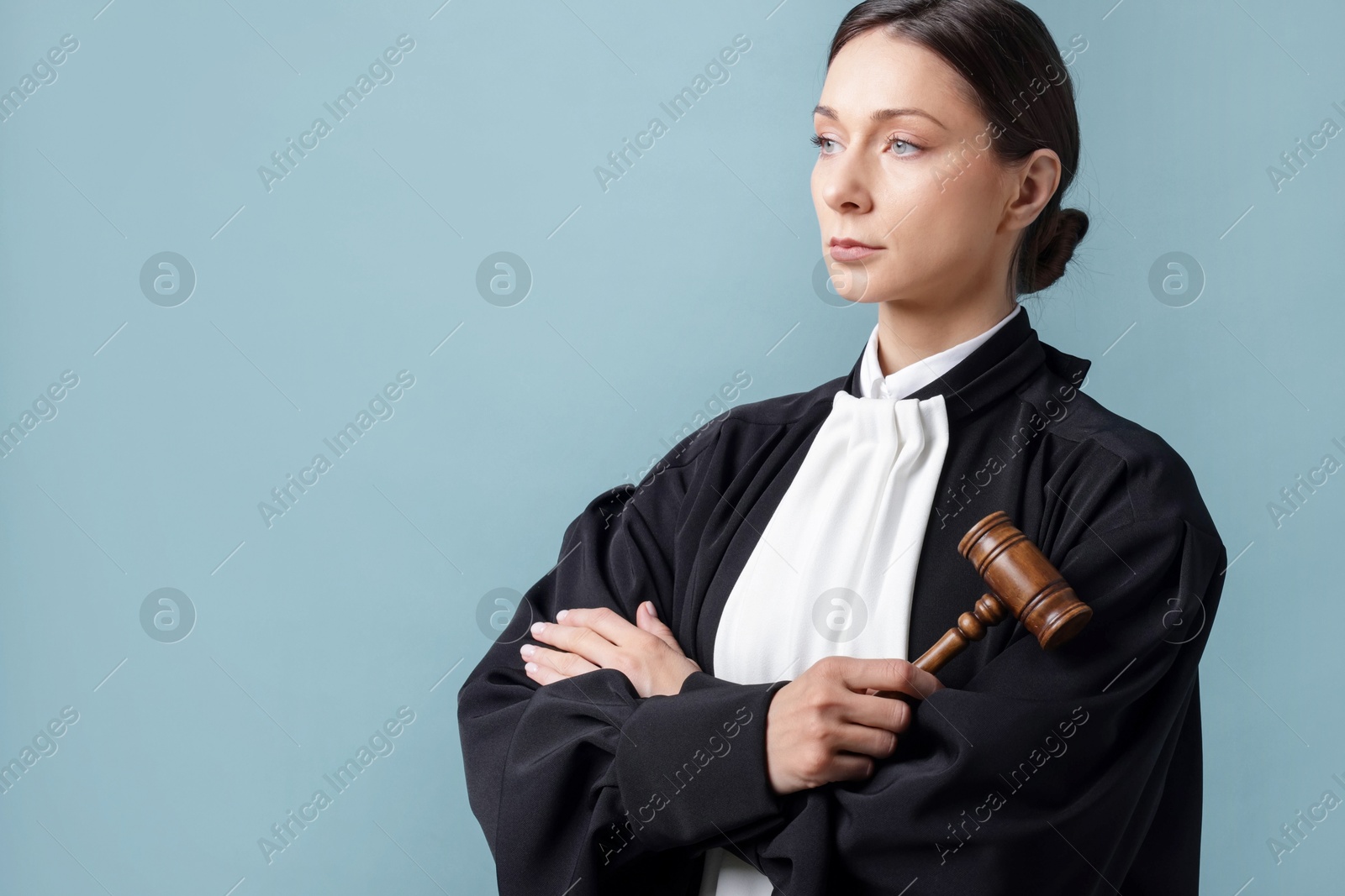 Judge with mallet on light blue background, space for text Photo of Judge with mallet on light blue background, space for text