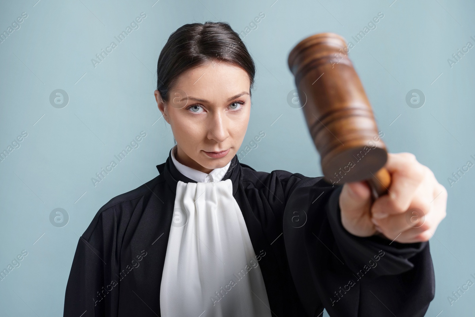 Judge with mallet on light blue background Photo of Judge with mallet on light blue background