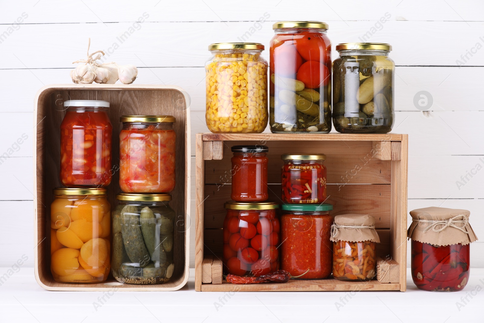 Many jars with different pickled products and ingredients on white wooden table Photo of Many jars with different pickled products and ingredients on white wooden table