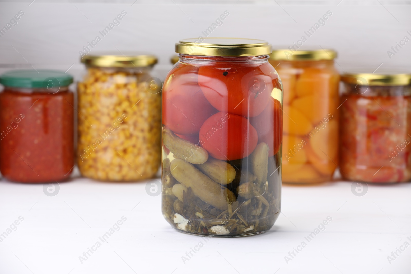 Many jars with different pickled products on white wooden table Photo of Many jars with different pickled products on white wooden table