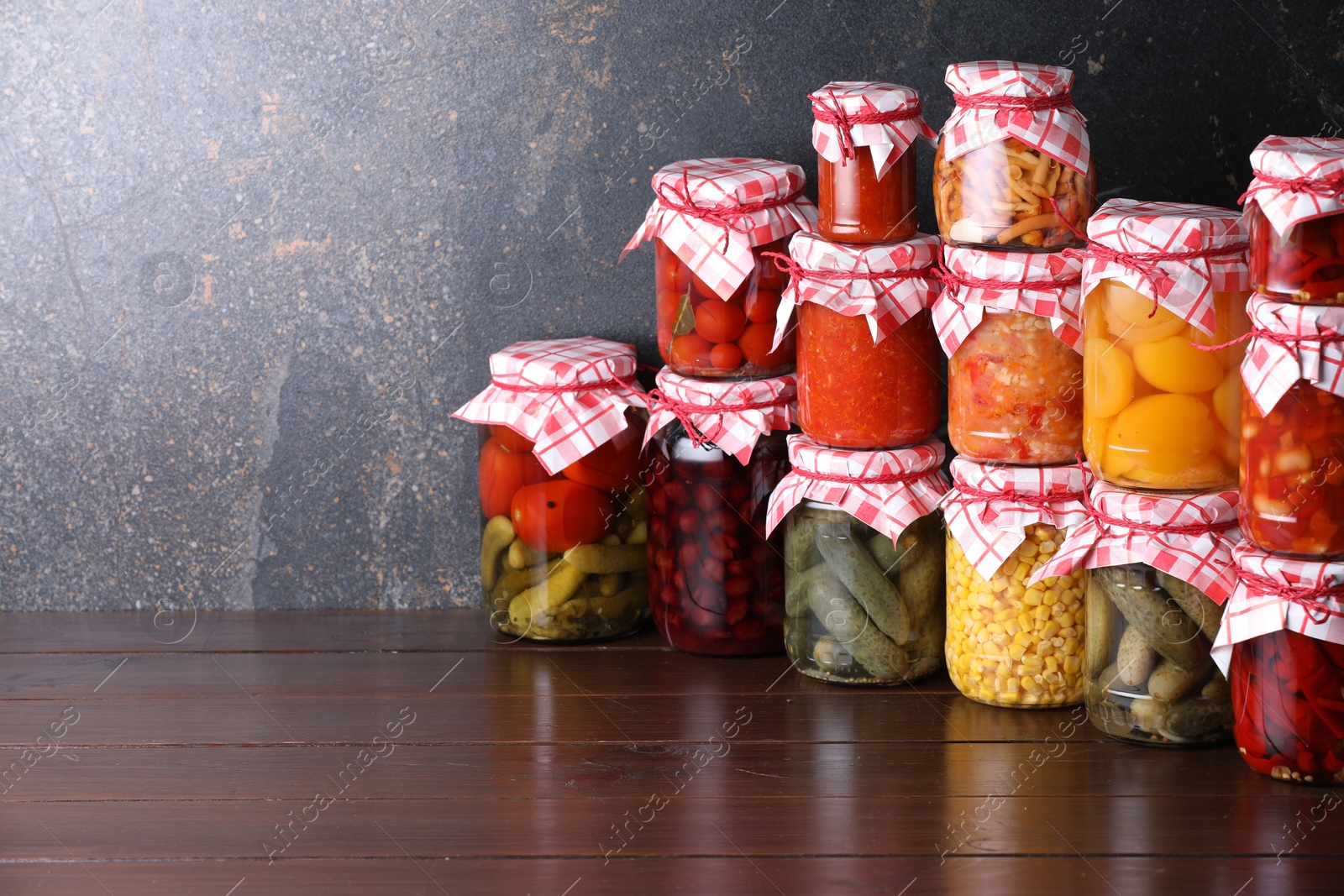 Many jars with different pickled products on wooden table, space for text Photo of Many jars with different pickled products on wooden table, space for text