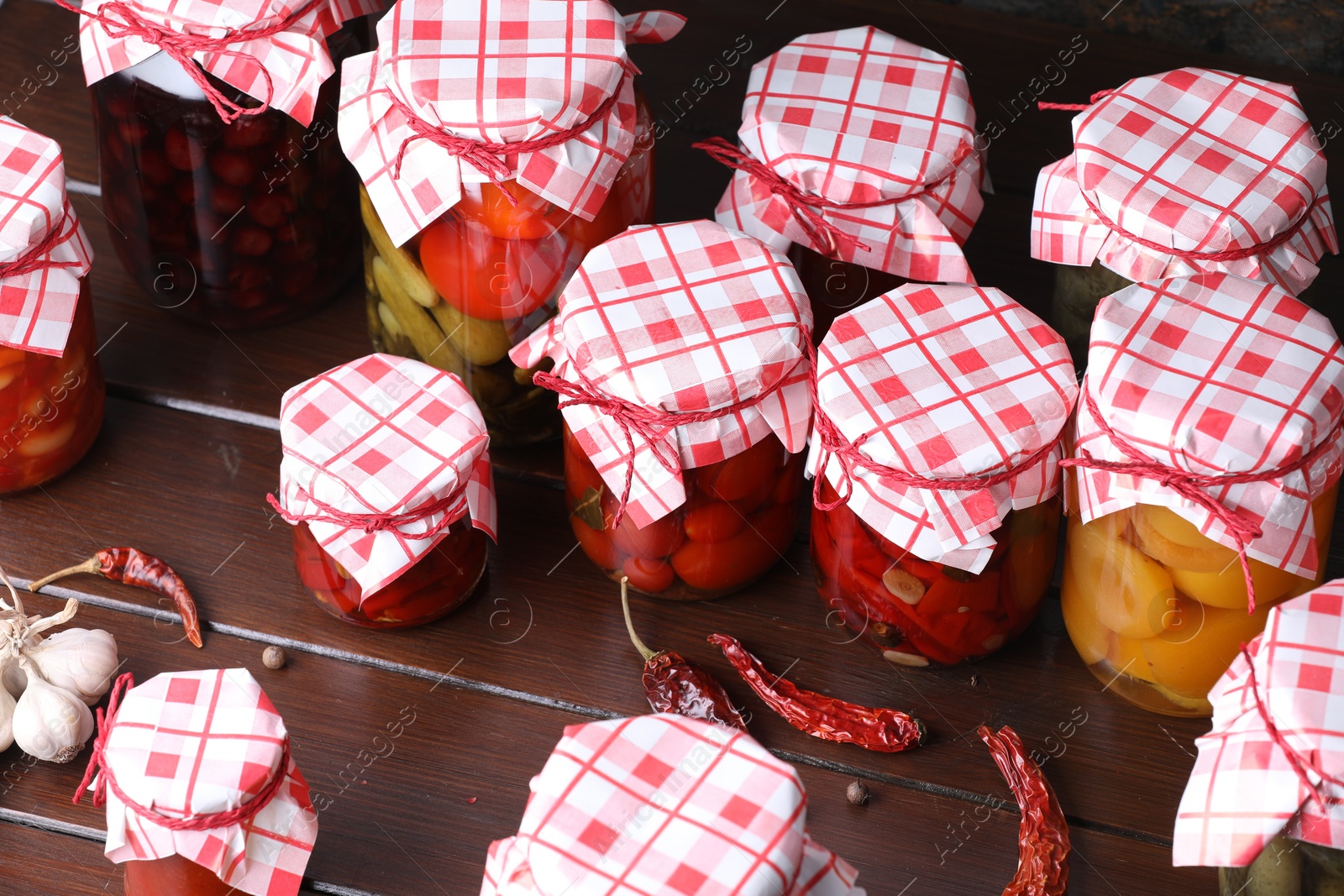 Many jars with different pickled products and ingredients on wooden table, above view Photo of Many jars with different pickled products and ingredients on wooden table, above view