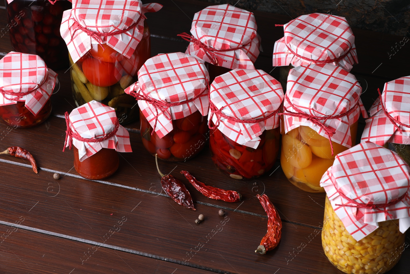 Many jars with different pickled products and ingredients on wooden table, above view Photo of Many jars with different pickled products and ingredients on wooden table, above view