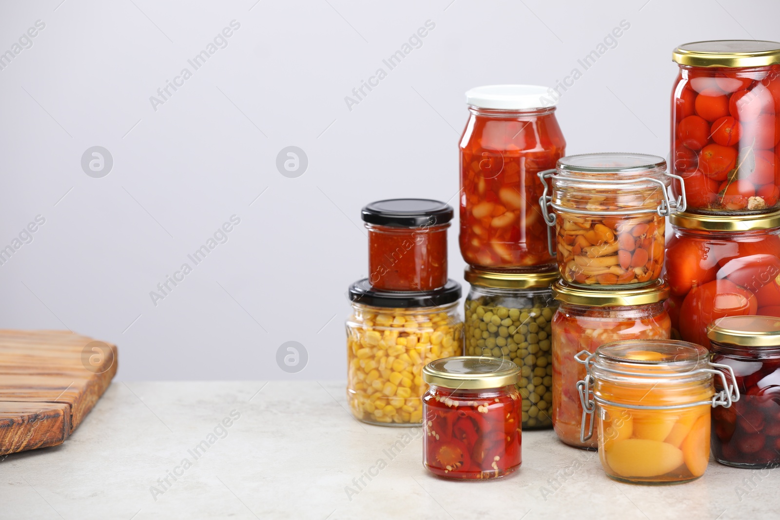 Many jars with different pickled products on light grey table, space for text Photo of Many jars with different pickled products on light grey table, space for text