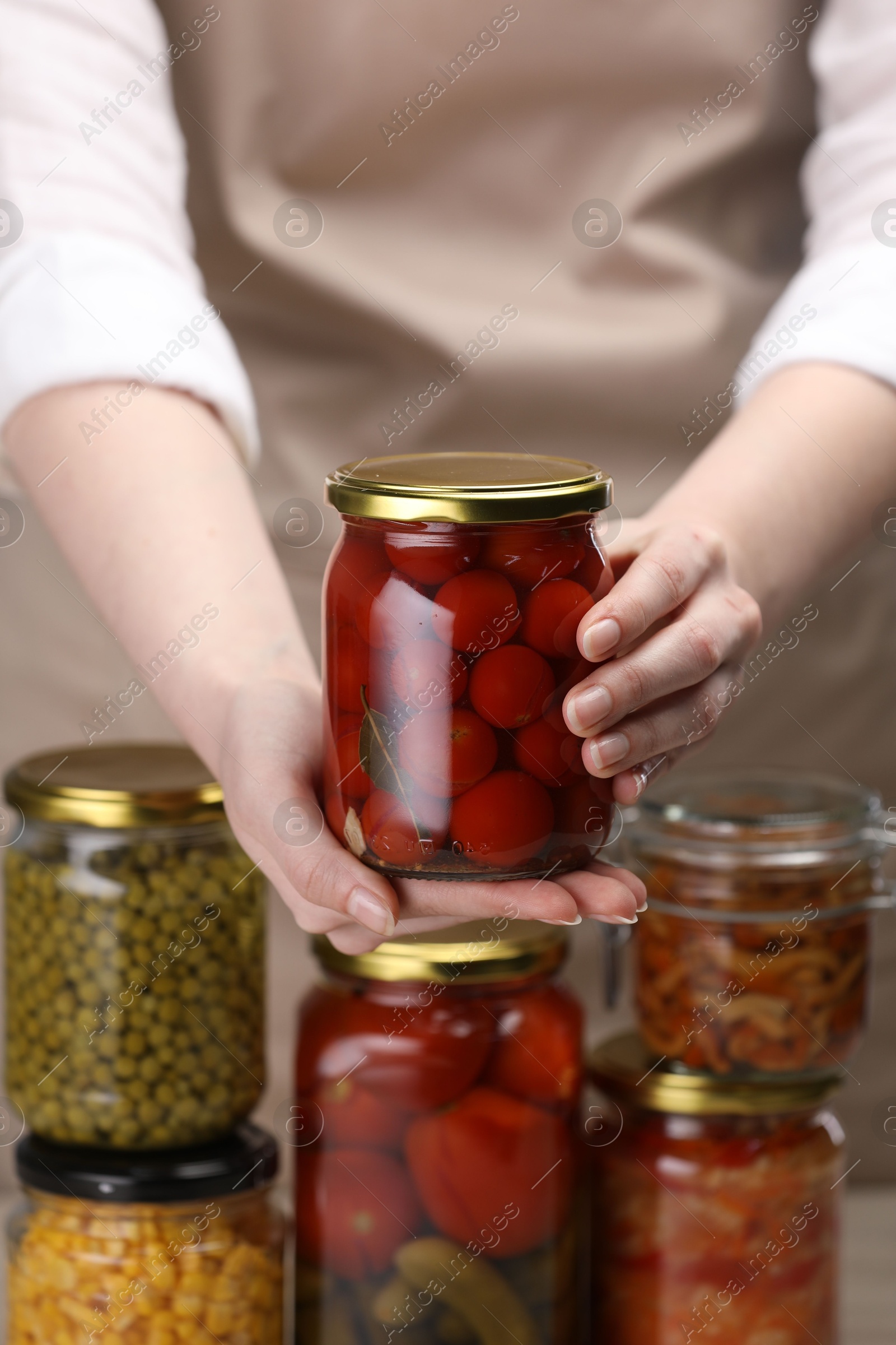Woman with many jars of different pickled products, closeup Photo of Woman with many jars of different pickled products, closeup