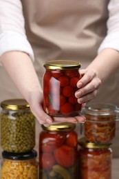 Photo of Woman with many jars of different pickled products, closeup