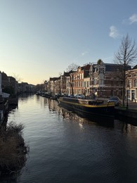 Photo of Leiden, Netherlands - March 9, 2025: Picturesque view of canal with moored boats in city