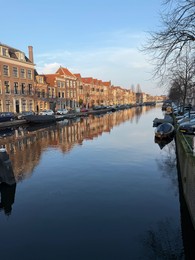 Photo of Leiden, Netherlands - March 9, 2025: Picturesque view of canal with moored boats in city