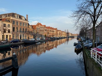 Photo of Leiden, Netherlands - March 9, 2025: Picturesque view of canal with moored boats in city