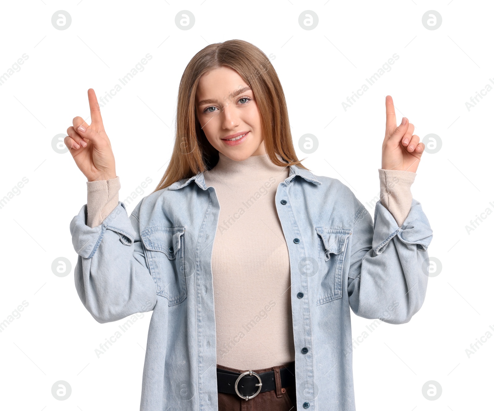 Photo of Portrait of smiling teenage girl pointing upwards on white background