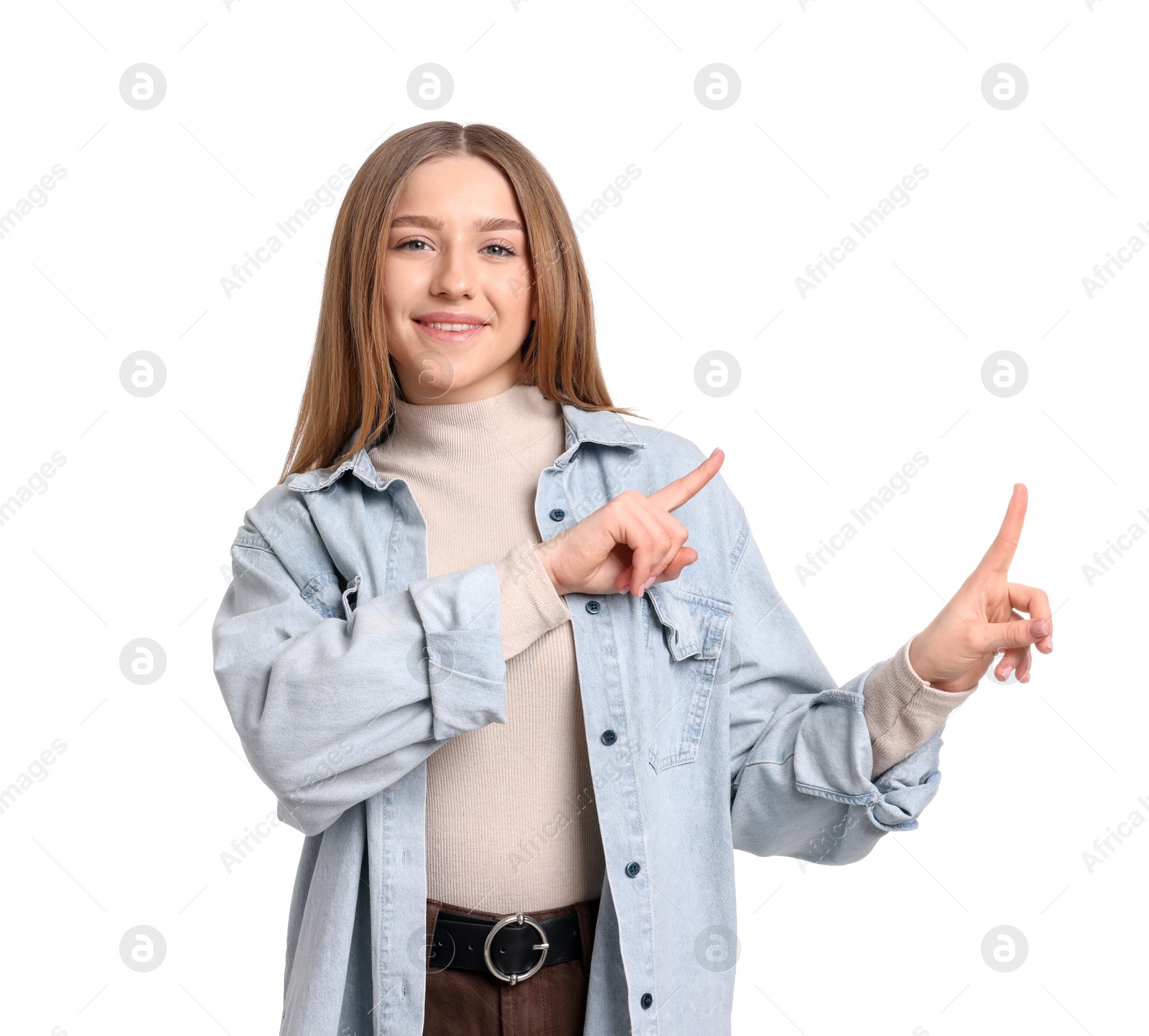 Photo of Portrait of smiling teenage girl pointing at something on white background