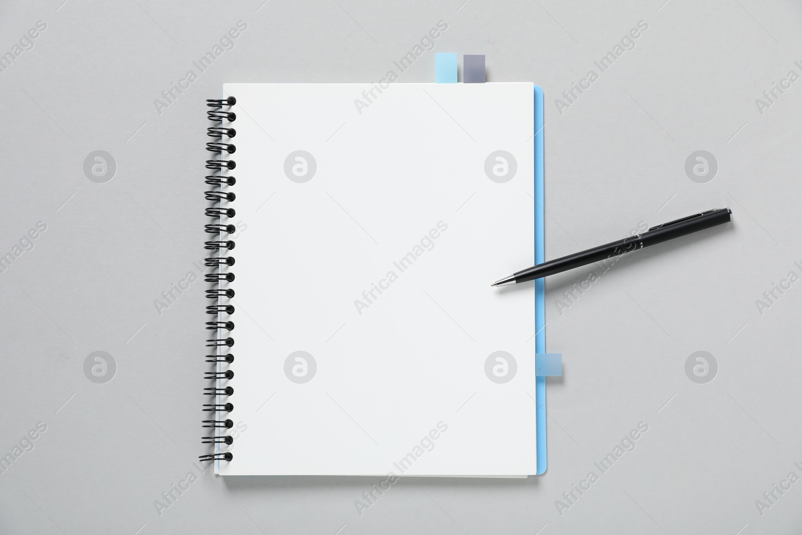 Open blank notebook with colorful stickers and pen on light grey background, top view Photo of Open blank notebook with colorful stickers and pen on light grey background, top view