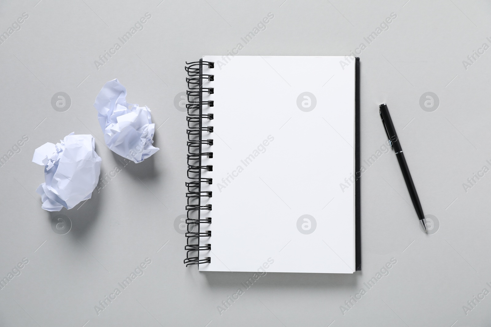 Open blank notebook, pen and crumpled paper on light grey background, flat lay Photo of Open blank notebook, pen and crumpled paper on light grey background, flat lay