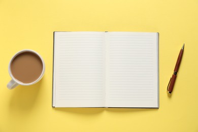 Photo of Open blank notebook, coffee and pen on yellow background, flat lay