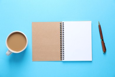 Photo of Open blank notebook, pen and coffee on light blue background, flat lay