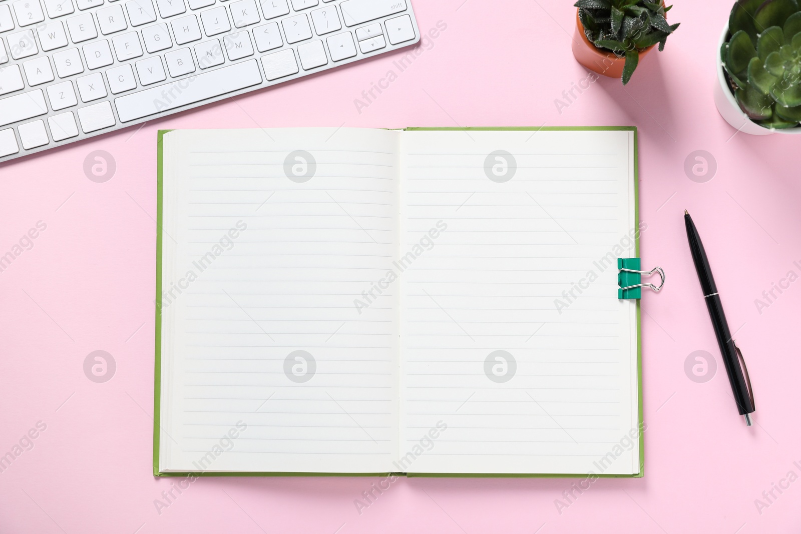 Open blank notebook, pen, computer keyboard and floral decor on pink background, flat lay Photo of Open blank notebook, pen, computer keyboard and floral decor on pink background, flat lay