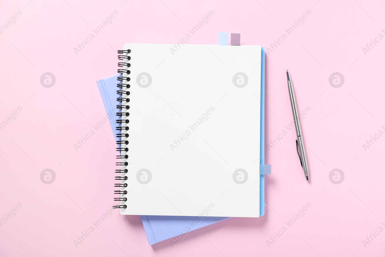 Open blank notebook and pen on pink background, flat lay Photo of Open blank notebook and pen on pink background, flat lay