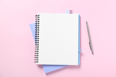 Photo of Open blank notebook and pen on pink background, flat lay